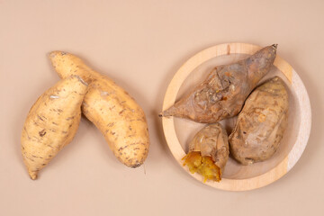 Sweet Cilembu sweet potatoes displayed raw and baked on a wooden plate, showcasing traditional Indonesian food, natural nutrition, and healthy lifestyle.