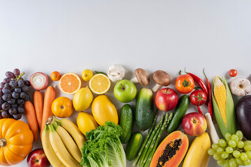 A vibrant assortment of fresh fruits and vegetables arranged on a white background