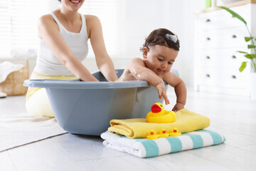 Mom bathing her little baby at home, closeup
