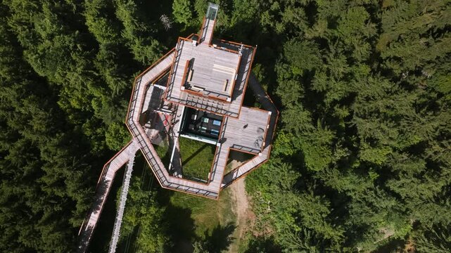 The aerial view over the top of wooden skywalk with glass lookout point surrounded by green forest in Beskid  Mountains, Czech Republic