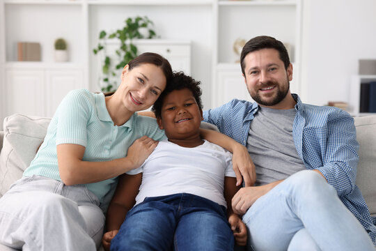 Adoption. Happy parents and their son at home