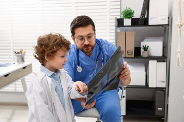 Obraz premium Choice of profession. Father and his son examining X-ray picture in clinic