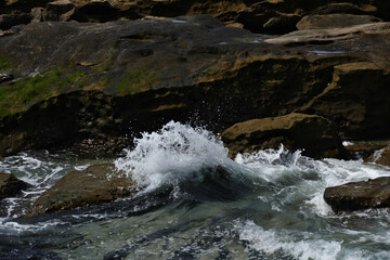 Pacific shore with white wave and blue ocean