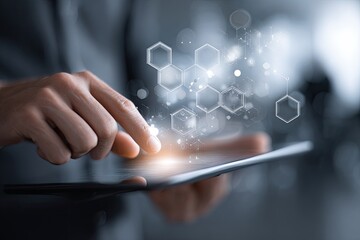 Close-up of hands interacting with a tablet, displaying abstract hexagonal shapes and glowing particles.  A blurred, neutral background suggests a modern workspace