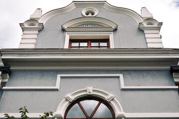 Historic building facade with arched windows, stucco details, and 1907 architectural design
