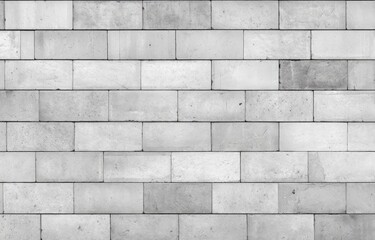 Fototapeta premium Monochromatic, light gray rectangular brickwork wall. Even rows of uniform blocks create a simple, textured surface