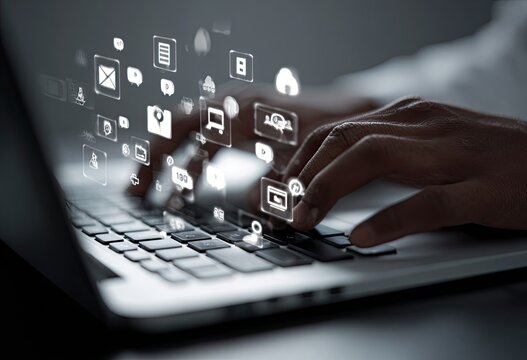 Close-up of hands typing on a laptop keyboard with digital icons overlayed