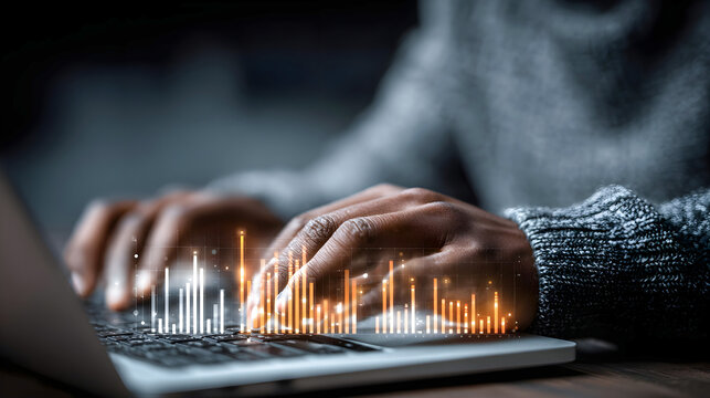 Close-up of hands typing on laptop keyboard with glowing digital data graphics overlay