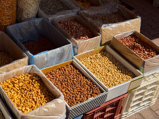 Assorted nuts and seeds arranged in boxes on outdoor market stall. Agriculture, farming, and seasonal food produce with nutrition and healthy lifestyle.