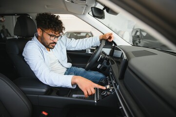Customer testing dashboard features in new car at dealership