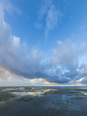 Obraz premium Low Tide Reflections under a Dramatic Cloudy Sky