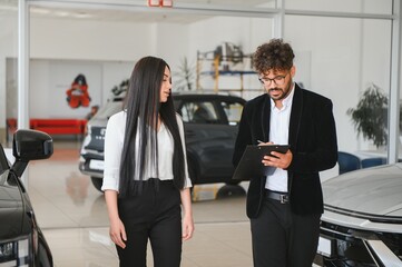 Arab Car salesman showing vehicles to customer in dealership