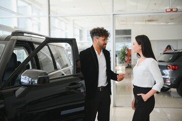 Arab Car salesman showing a new car to a customer in dealership
