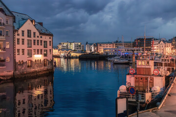 Fotografia nocturna de un paisaje acuatico y urbano en la bonita ciudad de Alesund, Noruega