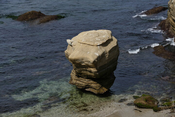 Standalone rock in pacific ocean wave
