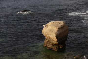 Standalone rock in pacific ocean wave