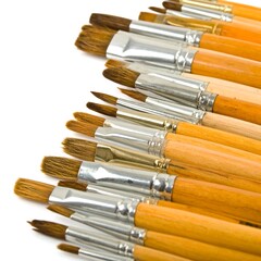 Fototapeta premium A collection of paintbrushes with wooden handles and metal ferrules arranged in a close-up shot.