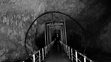 Black and white cave tunnel walkway with eerie vanishing point