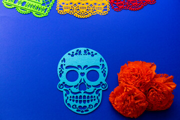 Day of the Dead decorations with colorful papel picado, cut-out skulls, and marigold flowers
