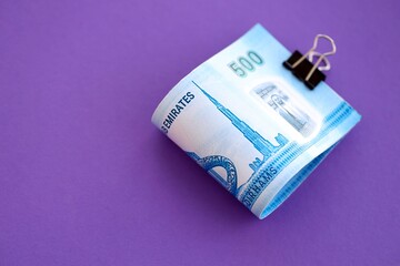 United Arab Emirates dirham money bills in big amount on purple. Finance and banking concept