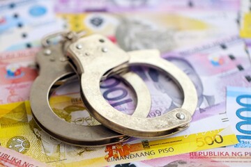 Philippines peso currency money bills and handcuffs. The concept of criminal