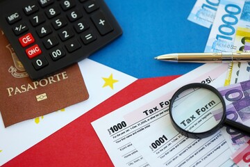 Philippines peso money bills and calculator with tax form on flag. Taxation and accounting concept