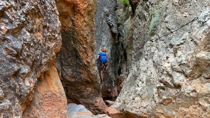 Climber on via ferrata trail, crossing a deep canyon. High quality 4k video