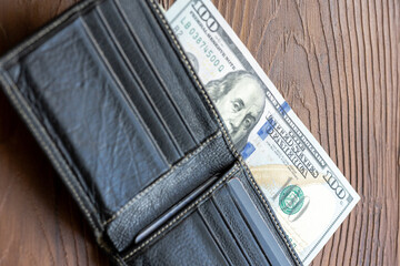Cash in Black: US Dollars Tucked Inside a Leather Wallet