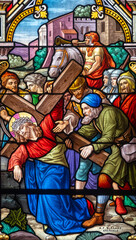 Stained glass (1914) of The Way of the Cross. Fifth station: Simon of Cyrene helps Jesus carry his...