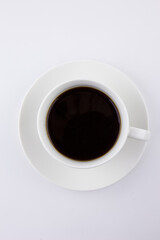 A cup of black coffee in a white cup and saucer against a white background.