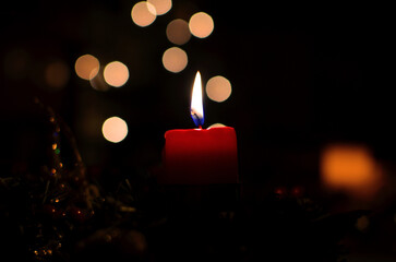 Red Pillar Candle in Festive Holiday Arrangement with Warm Bokeh Lights