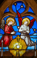 Stained glass (19th century) of two angels in adoration and prayer.
