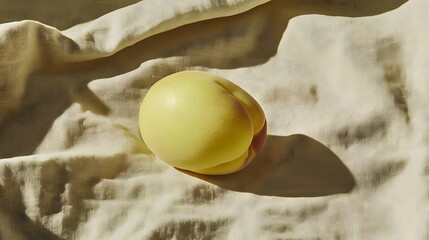Single Yellow Peach on Beige Fabric Drape Sunlight Still Life Photography
