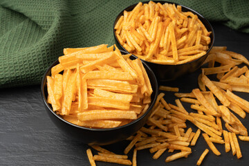 Fried chips sticks, finger potato chips, golden shoestring fries pile, French fries