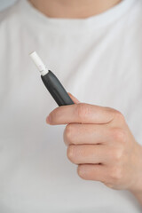 Faceless woman holding tobacco heating system. 