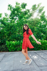 women in a red polka dot dress smiling on the street