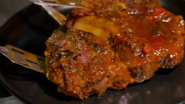 The cooked osso buco steak is placed on a plate. High quality 4k footage