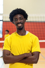 African american male partners in yellow jersey posing with arms crossed on gym court showing net