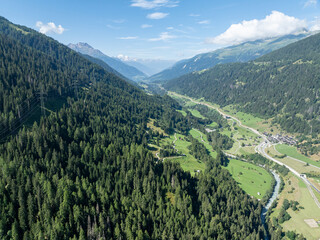 Aerial view of power line pylon in mountaineous area in Switzerland through valley in Canton of Valais.