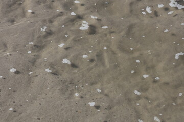 Water from the oceans tides moving in and out along the sand.
