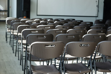 Rows of empty chairs await the arrival of guests at a modern event space in the afternoon