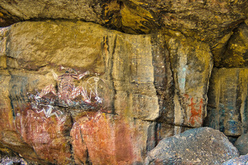 World Heritage rock art: figures from Aboriginal mythology above a group of men and women with ceremonial headdresses at Nourlangie (Burrunkuy), Arnhem Land, Kakadu, Northern Territory, Australia
