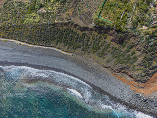 Waves crash against the volcanic shores of Tenerife, Spain, creating intricate textures in the...