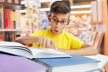 Happy school student reading book.