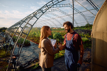 Happy farm owner welcoming insurance agent at his property. © Drazen