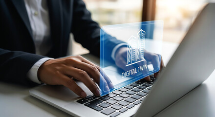 Person using laptop with digital twin building graphic overlay for architecture design and engineering work