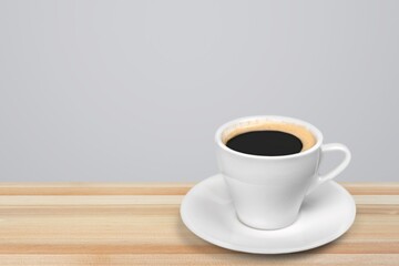 A ceramic cup with aroma coffee on a wooden table
