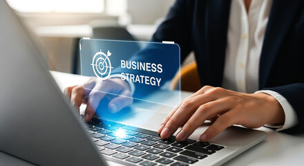 Person typing on laptop with business strategy overlay on screen in an office environment setting