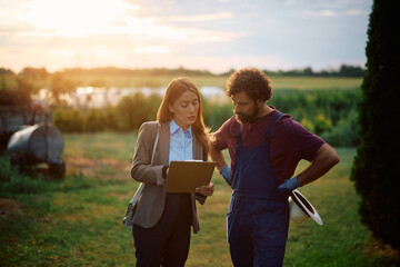 Farm owner and insurance agent analyzing a bank statement in the field.