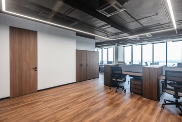 Minimalistic modern open space workplace with desk, chairs and large windows, Spacious open office with wooden floor and modern furniture